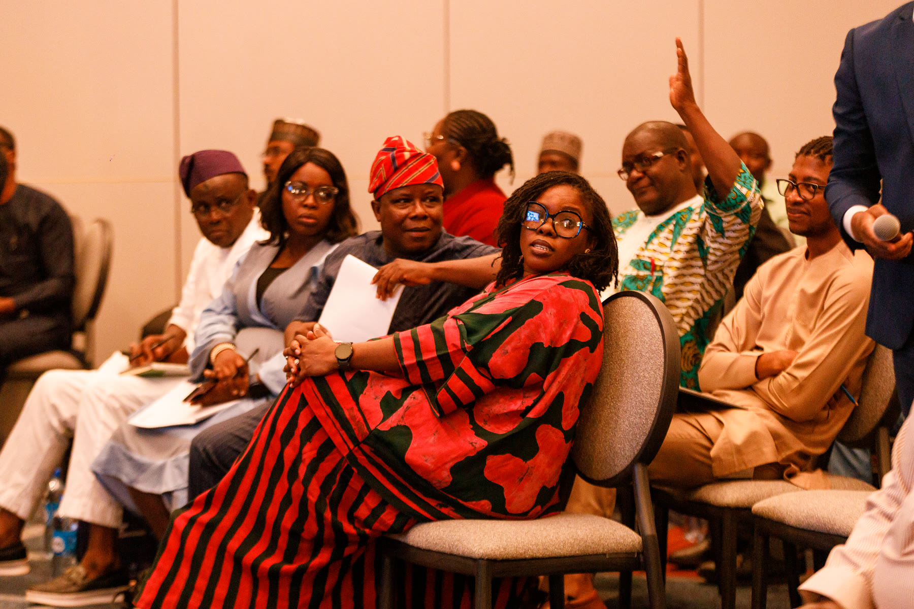 Delegates seated in the audience, listening closely.