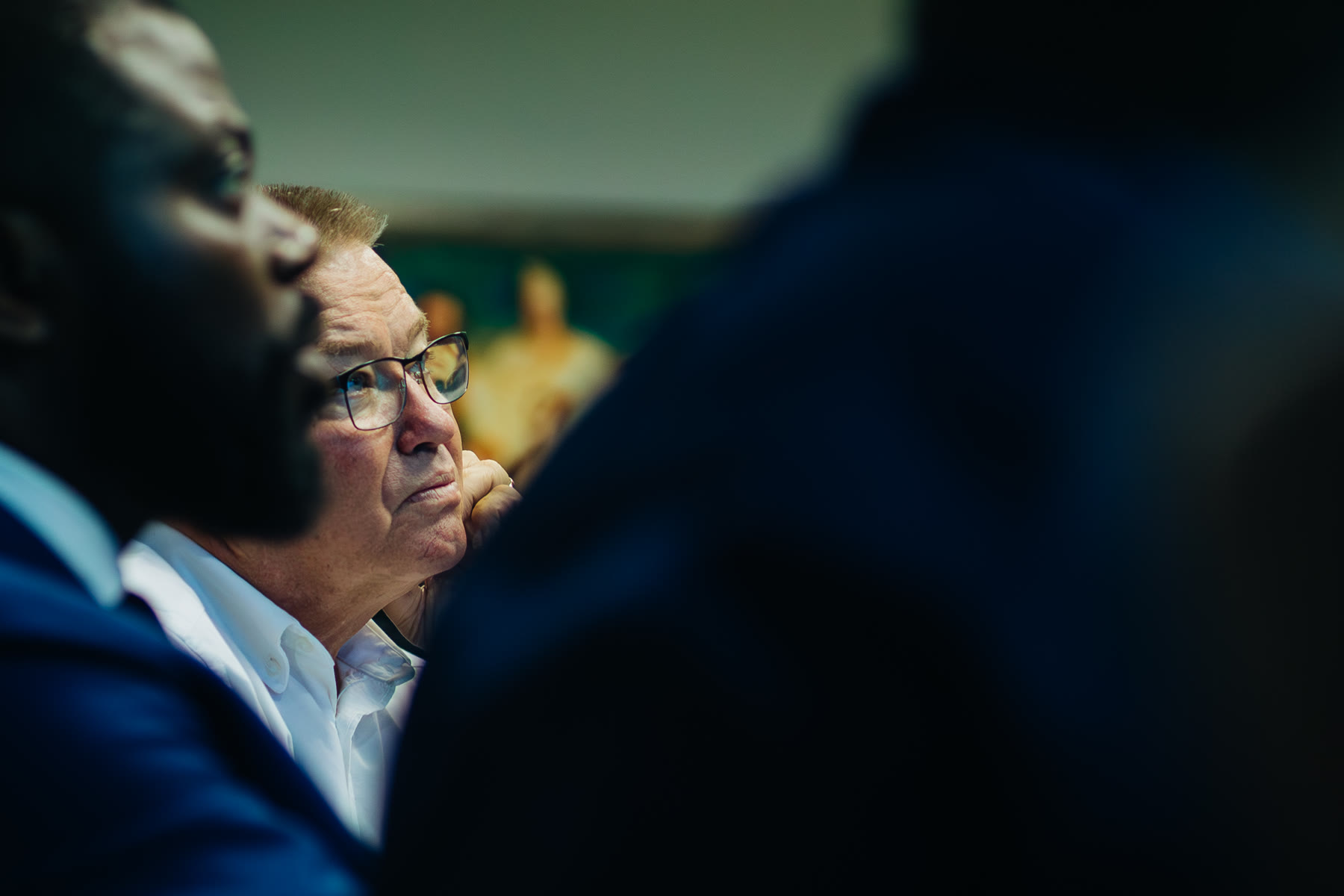 A close portrait of an attendee in conversation, shot through the foreground.