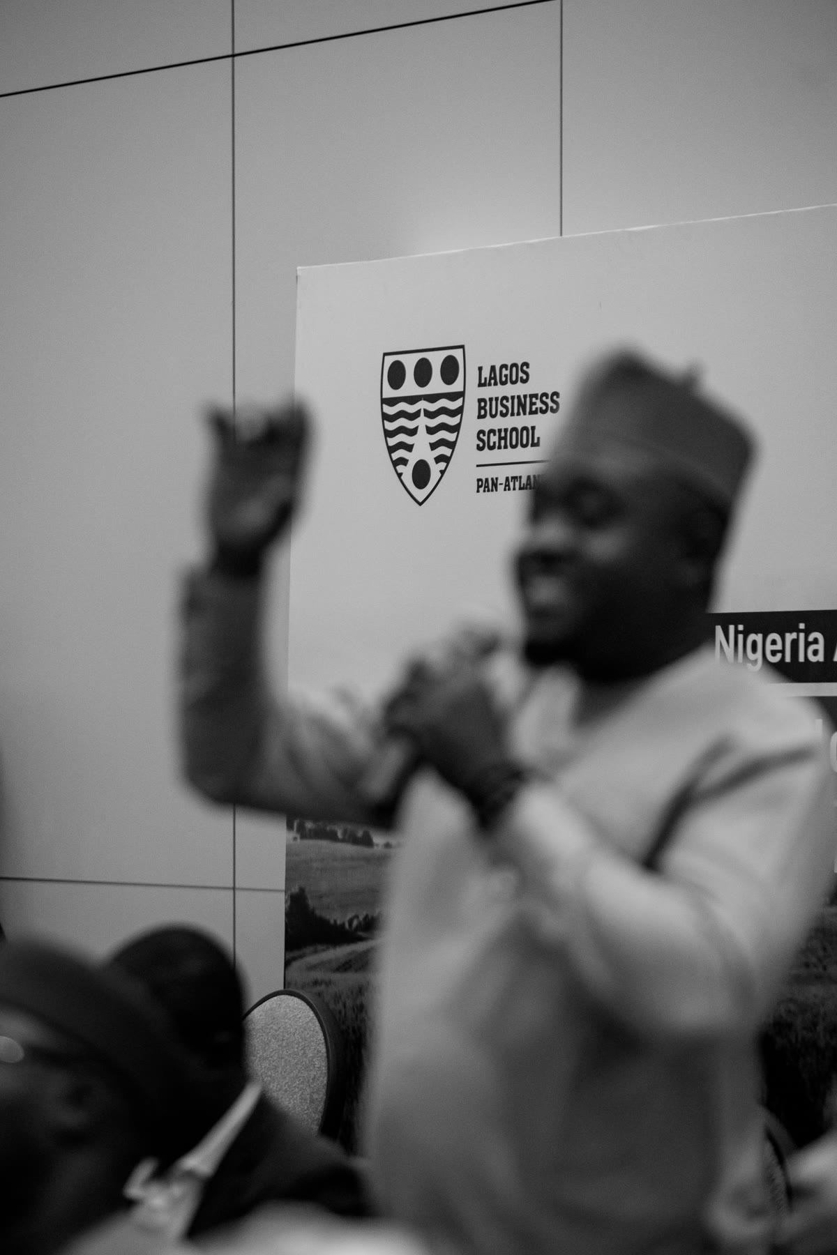 A speaker mid gesture, photographed in black and white.